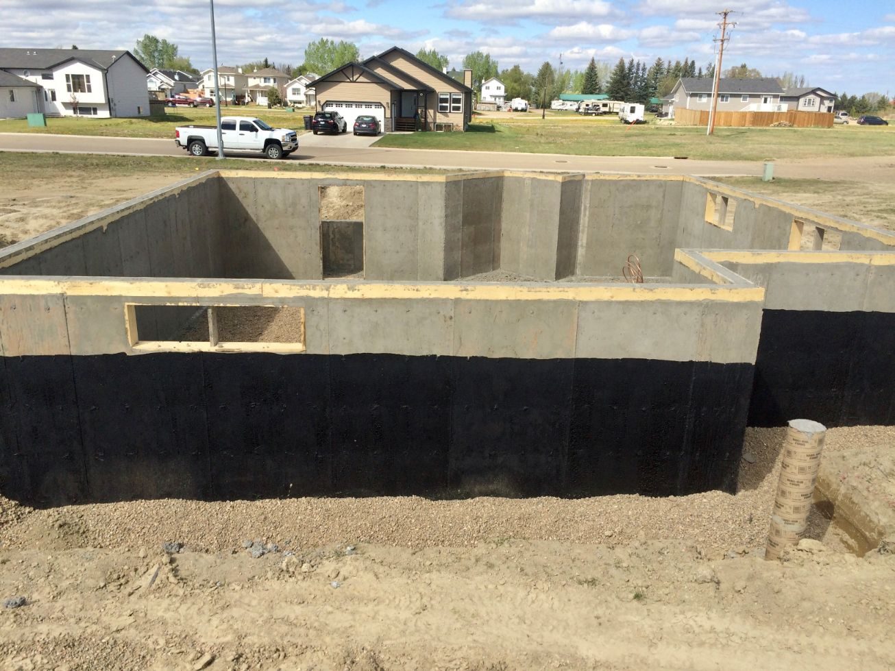 Basement foundation walls being poured and backfilled